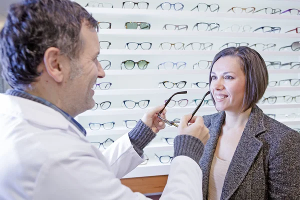 Óptico probando gafas a un cliente — Foto de Stock