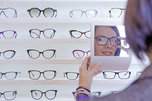 Provare gli occhiali con un piccolo specchio — Foto Stock