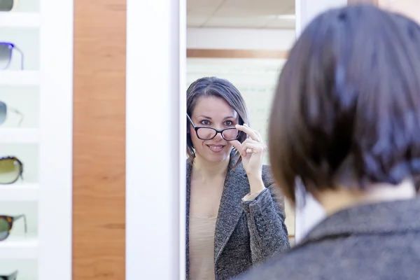 Young woman trying on glasses — Stock Photo, Image