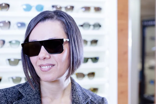 Usar gafas de sol en la tienda óptica — Foto de Stock