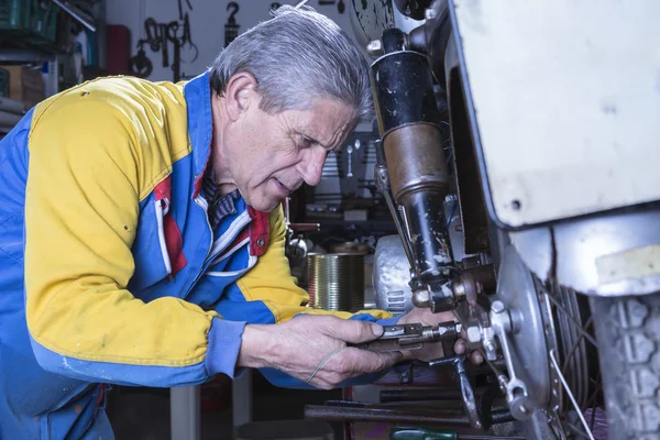 Un mecánico está arreglando un pie de moto —  Fotos de Stock