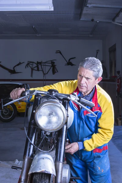 Male mechanic is starting a motorbik — Stock Photo, Image