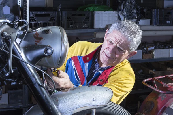 Mechanic fixing the motorcycle headligh — Stock Photo, Image