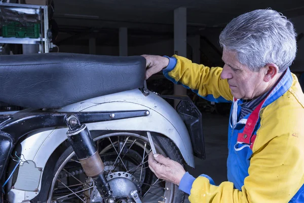 Mechanic is adjusting a motorbike sea — Stock Photo, Image