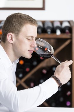 man smelling a glass of red win clipart