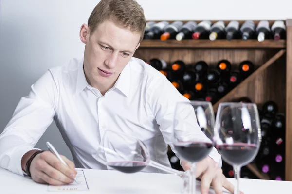 Male winemaker examining a wine glas — Stock Photo, Image