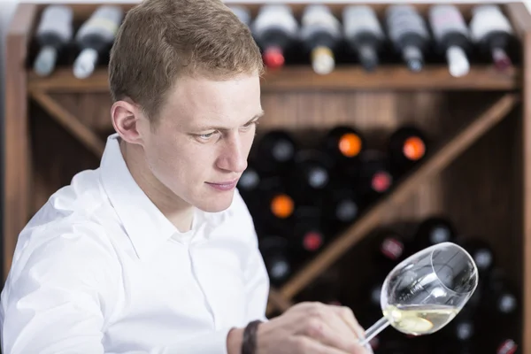 Hombre analizando una copa de vino blanco — Foto de Stock