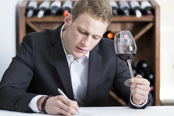 Man writing on a wine tasting shee — Stock Photo, Image