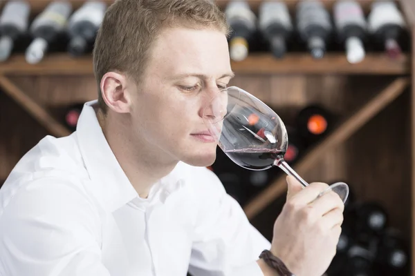 Ung man att lukta ett glas röd win — Stockfoto