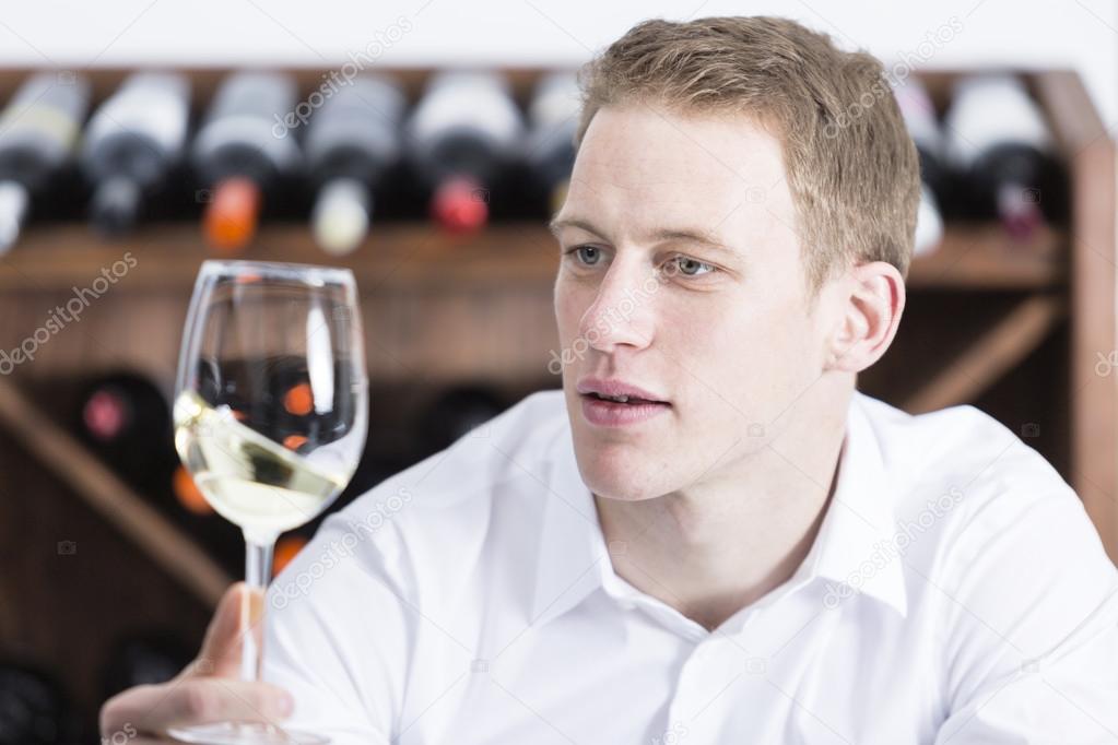 man shaking a white wineglas