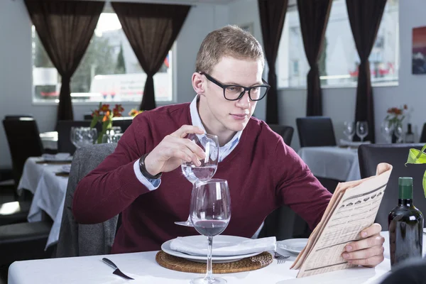 Businessman reading at a restaurant — Stock Photo, Image