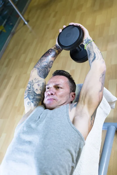 Man making dumbbell pull overs - workout routine — Stock Photo, Image