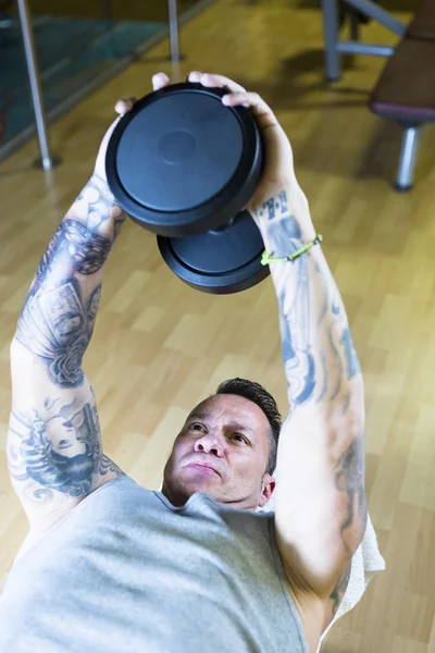 Jeune homme faisant haltère pull overs - routine d'entraînement — Photo