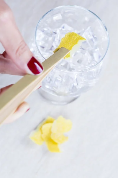 Adding a lemon peel to a gin toni — Stock Photo, Image