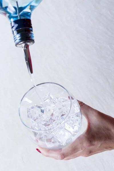 Att lägga till gin i en ballong glas — Stockfoto