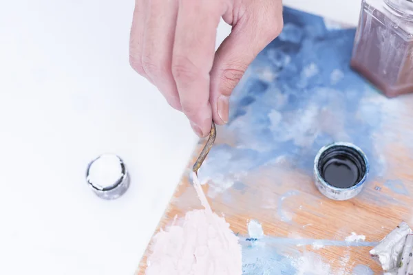 Hand of a painter mixing paint - painting session — Stock Photo, Image