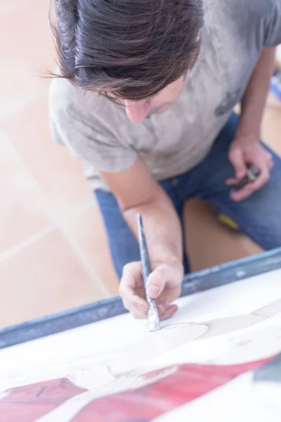 Young man painting on canvas - painting session — Stock Photo, Image