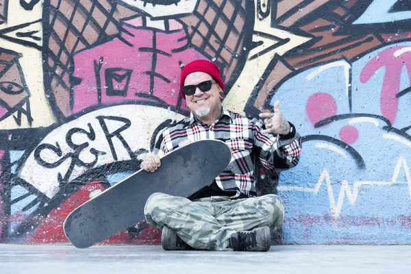 Portrait of an old man skater sitting — Stock Photo, Image