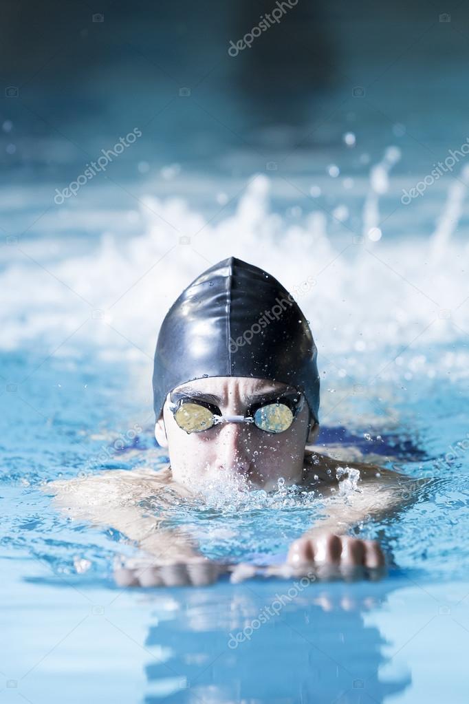 Male swimmer swimming with a swim board