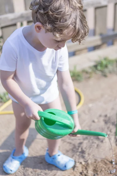 Młody chłopak ogrodnik podlewania — Zdjęcie stockowe