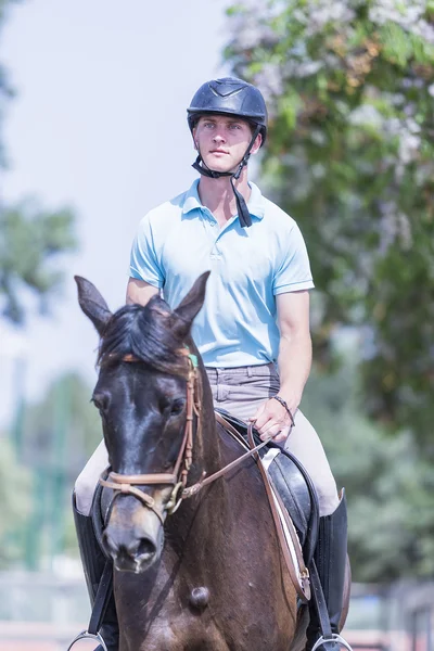 Boy riding a brown horse — Stock Photo, Image