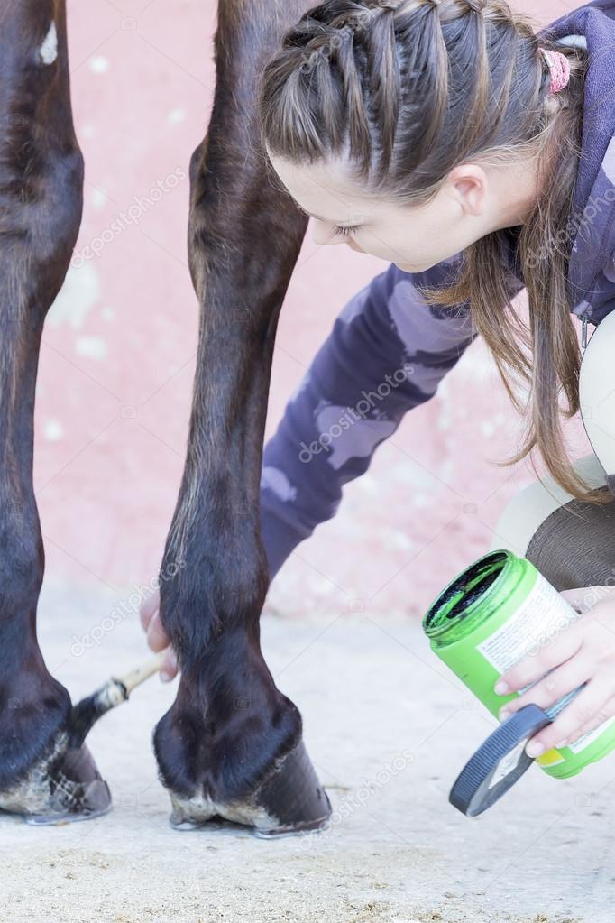 Girl grooming her horse