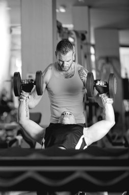genç bir adam halterle yardımcı antrenör