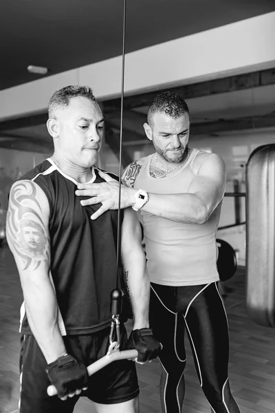 Personal trainer helping man — Stock Photo, Image