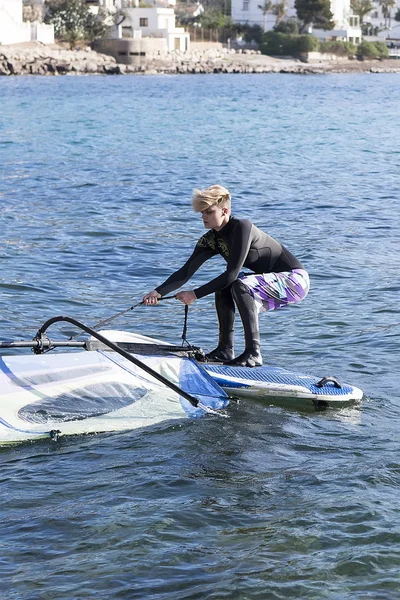 Menina windsurfista levantando sai — Fotografia de Stock