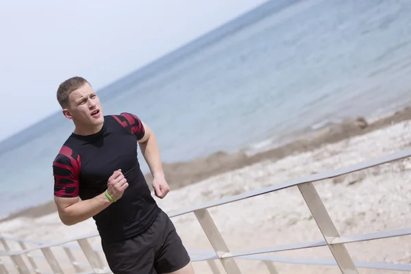 Mannelijke atleet uitgevoerd op het strand — Stockfoto