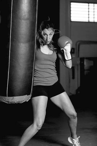 Boxer femminile che scalcia il sacco da boxe — Foto Stock