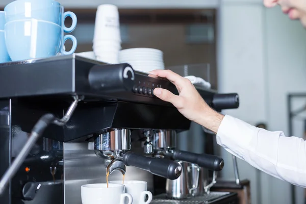 Bartender pushing the button on coffee machine — Stock Photo, Image