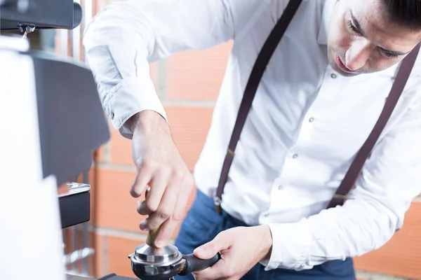 Close-up of bartender pressing coffee in holder — Stock Photo, Image