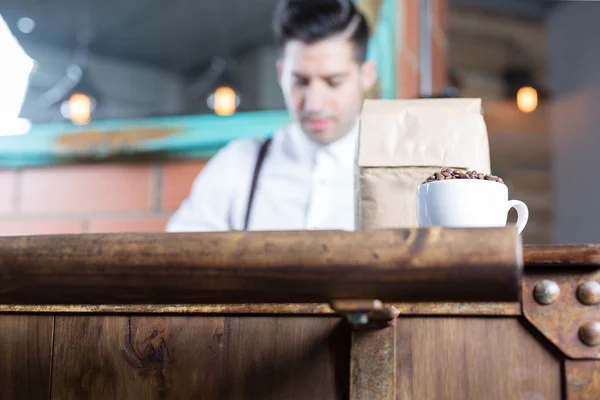 Nahaufnahme von Kaffeebohnen in Tasse und Papiertüte — Stockfoto