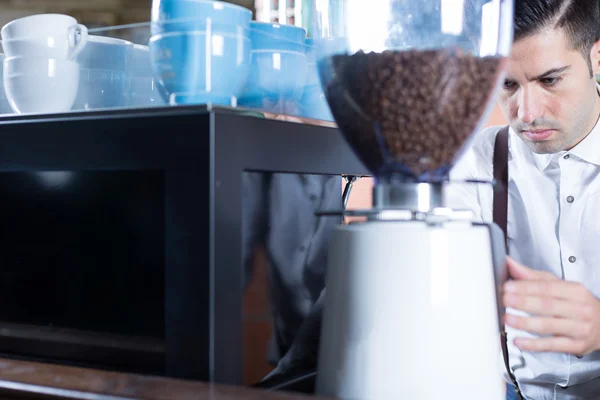 Barman maalt koffie bonen — Stockfoto