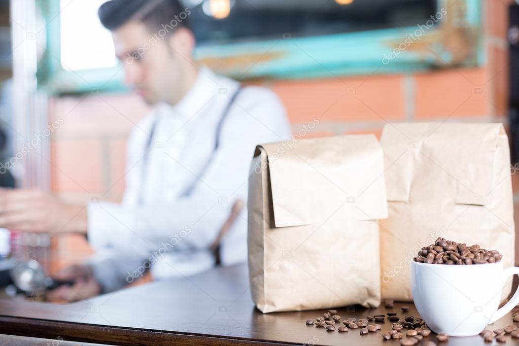 Coffee beans in cup and two paper bags