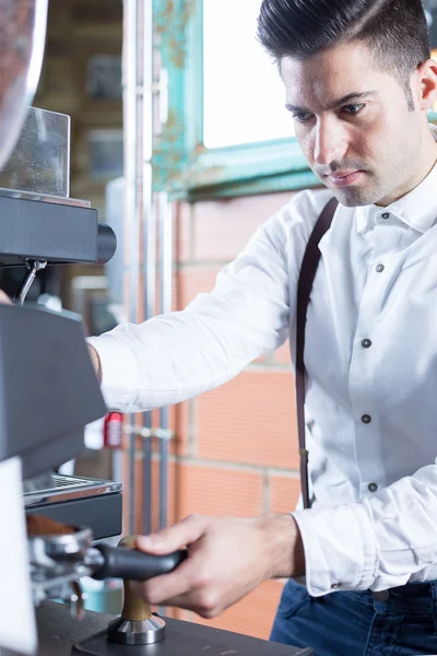 Porträt eines gutaussehenden Barkeepers, der Kaffee mahlt — Stockfoto