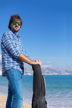 Güneşli sahil şeridi üzerinde güneş gözlüğü sakallı adam portresi