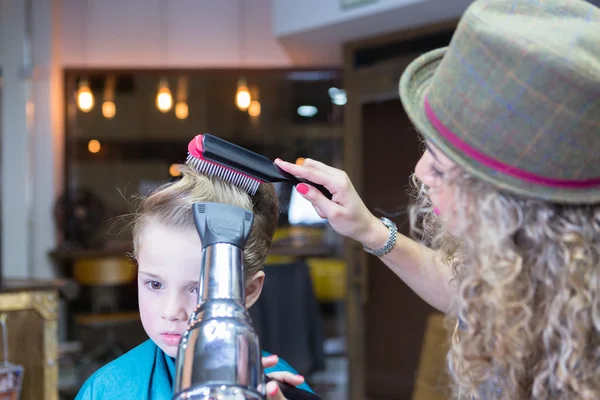 Hairdresser blowing dry boy hair — Stock Photo, Image