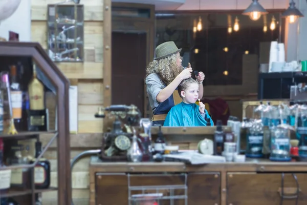 Mirror reflection of hairdresser and boy — Stock Photo, Image