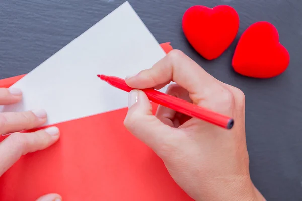 Vrouw handen met envelop en rood voelde pen Rechtenvrije Stockfoto's