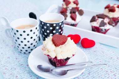 Bir şekilde dekore edilmiş cupcake ve iki bardak kahve