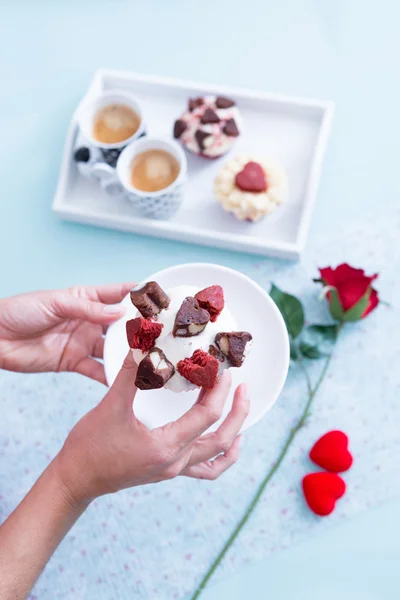 Manos sosteniendo cupcake de San Valentín en platillo — Foto de Stock