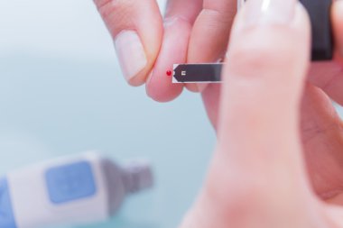 Doktor diyabetik hasta için test şeridi kullanarak