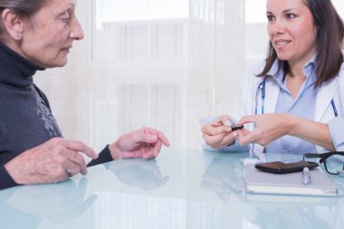 Kadın Doktor hastanın diyabet Şeker Ölçüm Çubuğu Strip gösterilen