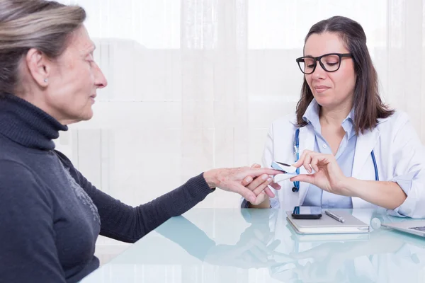 Doctor showing patient usage of medical device — Stock Photo, Image