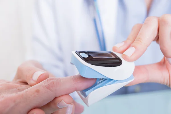 Médico e paciente usando oxímetro de pulso do dedo — Fotografia de Stock