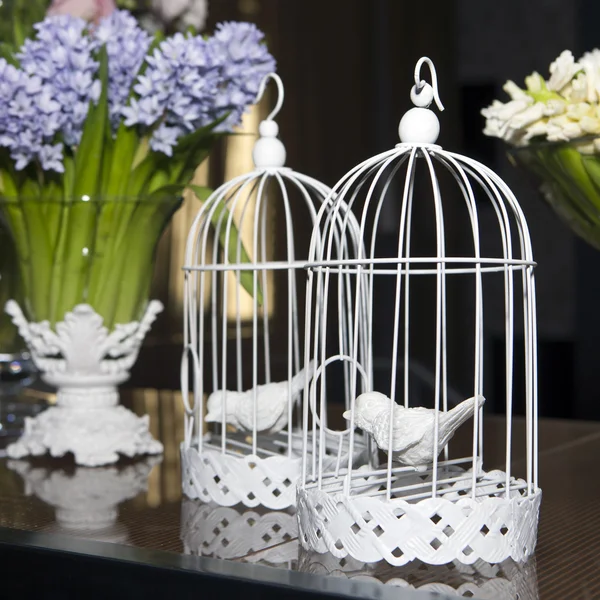 Vintage silla y mesa con flores en el frente y jaulas — Foto de stock