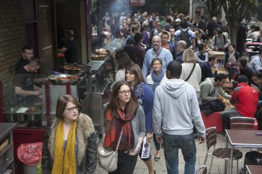 İnsanlar yürümek tarafından birisi bir fırında personel tarafından hizmet verilmektedir iken