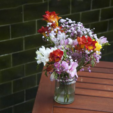 Tatlı pea, Lathyrus odoratus, buket ahşap duran bir mor Vazoda Çiçekler adımlar gri.
